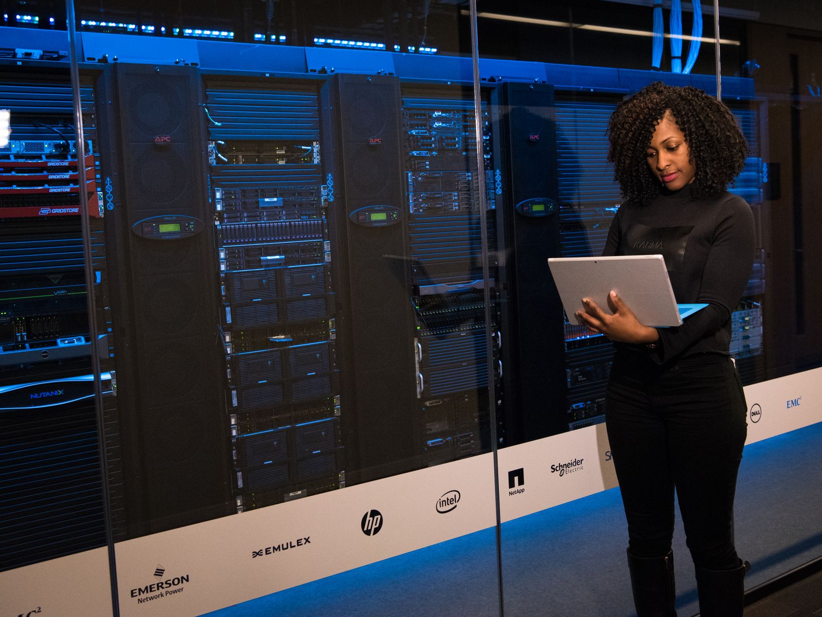 Engineer with a laptop checking network equipment racks in a data centre